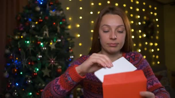 Frau las große positive Karte in Weihnachten. Fühlt sich glücklich an. Weihnachtszeit zu Hause Feiertage und Feiern Konzept — Stockvideo