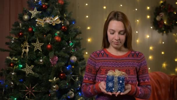 Молодая женщина дарит подарочный сертификат. Happy New Year celebration merry holiday concept — стоковое видео