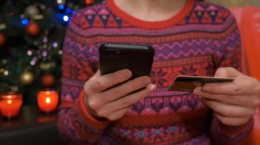 Noel 'de kredi kartıyla internetten alışveriş yapan kadının yakın çekimi.