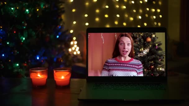 Mujer sonriente en un videocall, ella es feliz y deseando una feliz Navidad en línea — Vídeos de Stock