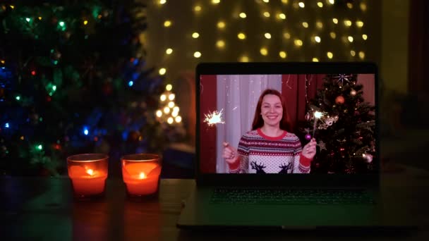 Glückliche Frau mit Wunderkerzen lacht und gratuliert Verwandten per Laptop online zu Weihnachten — Stockvideo