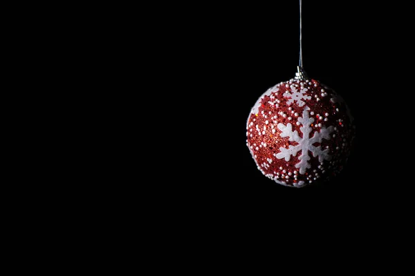 Siyah arka planda beyaz yıldızlı kırmızı Noel balonu. Yeni yıl ve Noel konsepti. İzole edilmiş. Yüksek kalite fotoğraf