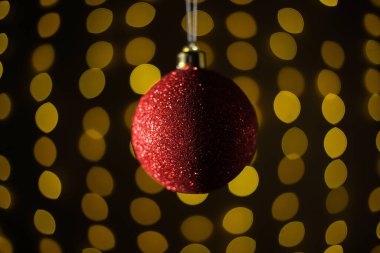 Kırmızı Noel topu arka planda çelenkler. Noel ve yeni yıl konsepti. Bokeh çelenkleri. Yüksek kalite fotoğraf