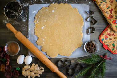 Noel ve yeni yıl kutlaması gelenekleri. Geleneksel şenlik yemekleri. Arkadaşlar çiğ zencefilli kurabiye hamuru kesiyor. Yüksek kalite fotoğraf