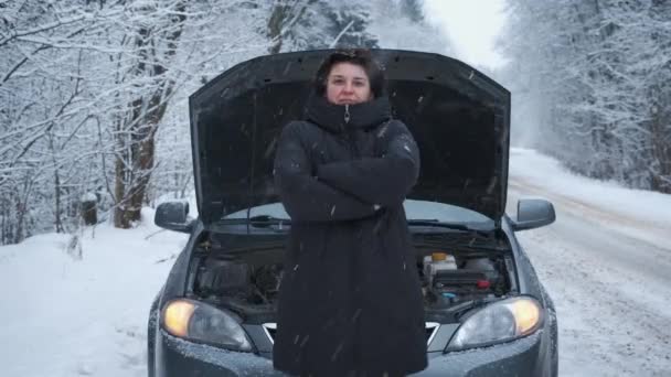 Frau im Winterwald auf der Straße, kalte, warme Hände, die auf Hilfe warten, die Motorhaube geöffnet — Stockvideo