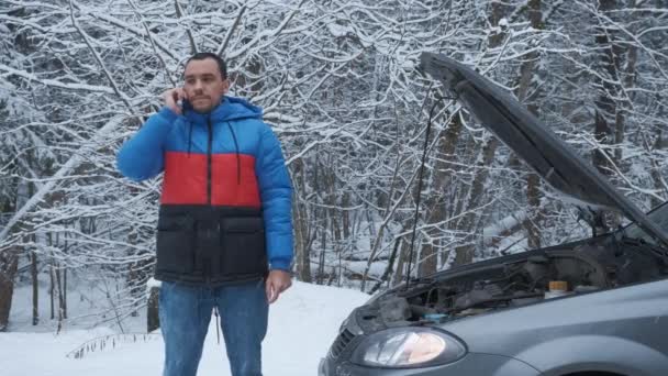 Trauriger Mann steht neben kaputtem Auto und ruft Rettungsdienst. — Stockvideo