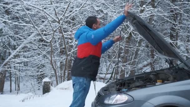 Besviken ung man öppna motorhuven av trasiga bilen för att kontrollera motorn. — Stockvideo