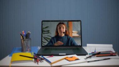Bilgisayar aracılığıyla çevrimiçi video iletişimi. Genç kadın internette öğretmenlik yapıyor.