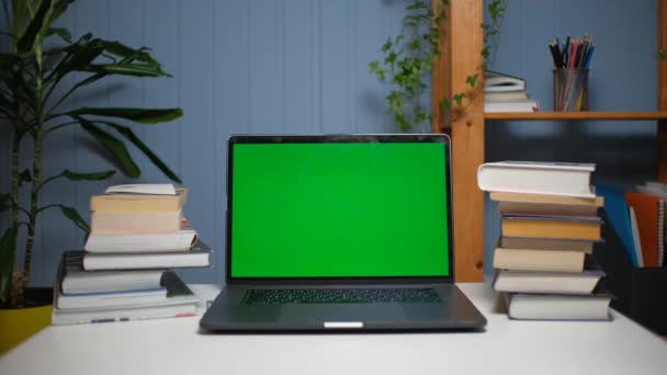Computer portatile a schermo verde su una scrivania con libri — Video Stock