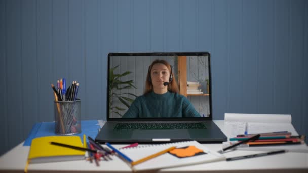 Een jonge vrouw geeft online les via videocommunicatie. — Stockvideo