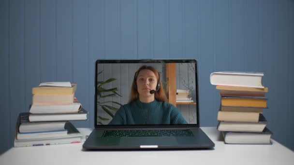 Een jonge vrouw geeft online les via videocommunicatie. — Stockvideo