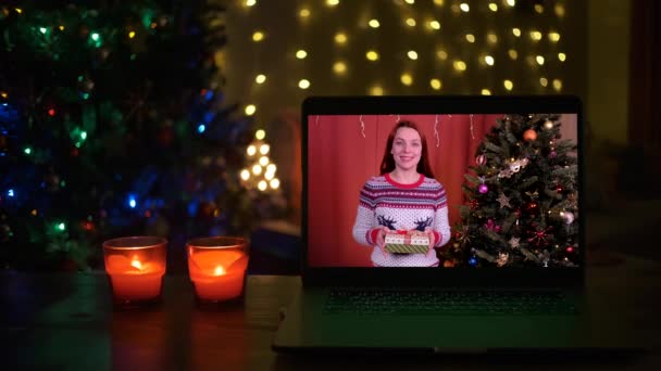 Feliz joven mujer dar caja de regalo de Navidad. Videollamada por computadora reunión virtual chat con la familia, distancia social — Vídeos de Stock