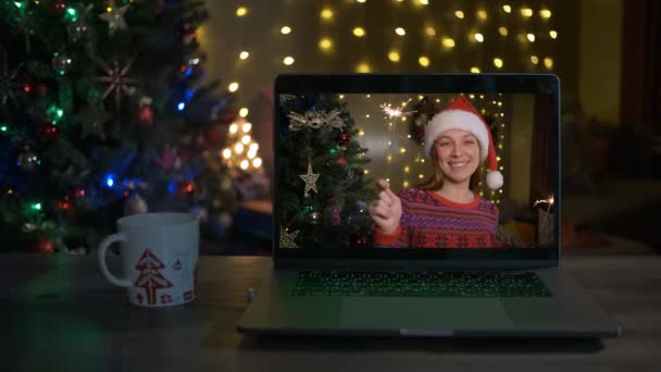 Mujer feliz con bengalas felicita a sus familiares en Navidad a través de la computadora portátil en línea. — Vídeos de Stock