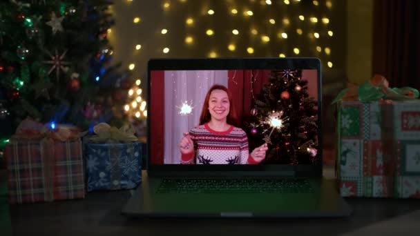 Mulher feliz com faíscas parabeniza parentes no Natal via laptop online. — Vídeo de Stock