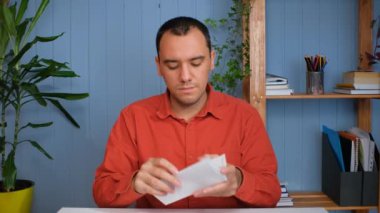 Genç iş adamı başarılı bir haber alır, ofiste oturur..