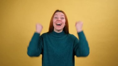 Kazanan jest yapan Amerikalı genç kadın stüdyoda turuncu arka planda 