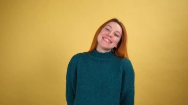 Gülümseyen neşeli genç kadın sarı arka plan stüdyosunda yalnız poz veriyor. İnsanlar samimi duygular yaşam tarzı konsepti.