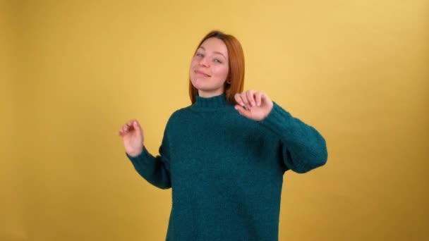 Capelli rossi giovane donna su sfondo arancione brillante in studio. Concetto di stile di vita. Ballando scherzare divertirsi — Video Stock