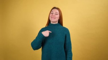 Ben buyum. Kendine güvenen gururlu, kendine güvenen, güzel görünümlü, sıradan giysiler içinde kendini gösteren ve kibirli bir şekilde bakan genç bir kadın. Stüdyo çekimi sarı arkaplanda izole edildi