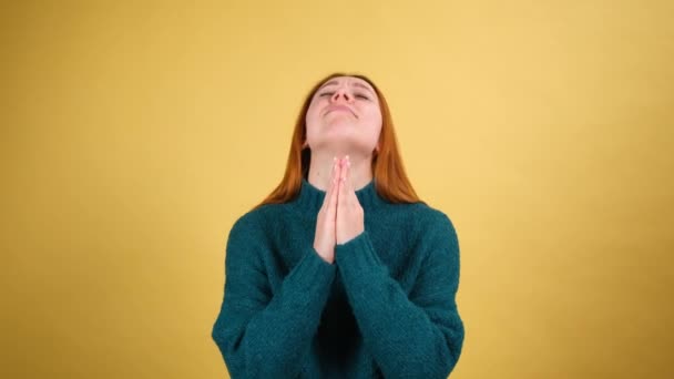 神よお願いだ。祈りのジェスチャーを維持し、助けを求めると、天に訴える若い女性を動揺させます。黄色の背景に隔離された室内 — ストック動画