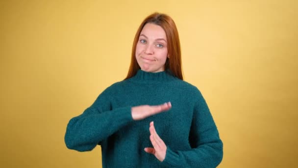 Mujer joven cansada mirando con ojos suplicantes asustados y mostrando el gesto de las manos fuera de tiempo, pidiendo descanso, necesita una pausa y descanso. interior aislado sobre fondo amarillo — Vídeos de Stock