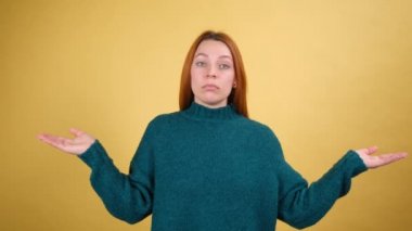 Bilmiyorum, kimin umurunda. Mutlu, güzel bir kadın omuzlarını silkiyor, belirsiz bir ifadeyle bakıyor, kayıtsızlık belirtileri gösteriyor. Sarı arka planda izole edilmiş kapalı stüdyo çekimi