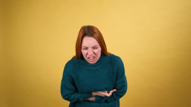 Akute Bauchkrämpfe. Kranke junge Frau mit Bauchschmerzen, Sodbrennen, Verstopfung, Magen-Darm-Problemen. isoliert auf gelbem Hintergrund — Stockvideo