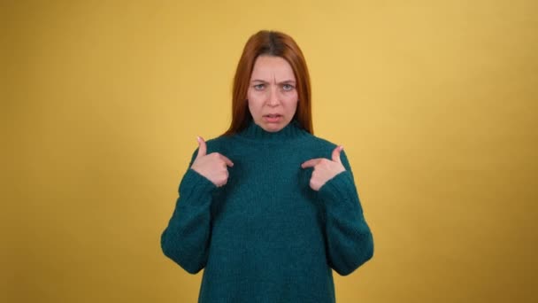 Divertente giovane donna guardando la fotocamera e puntando il dito si chiede dire chi sono no grazie non ne ho bisogno. Isolato su sfondo giallo in studio. Concetto di lifestyle. — Video Stock