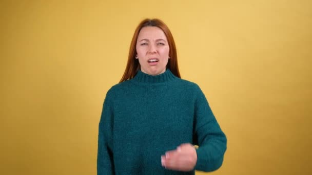 Repulsión al mal olor. Chica pelirroja agarrando la nariz con los dedos, conteniendo la respiración para evitar el hedor, gases de pedo horribles, olor intolerable, mostrando gesto de parada. Estudio plano aislado sobre fondo amarillo — Vídeo de stock