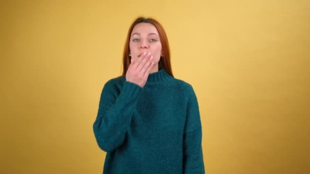 Abbastanza affascinante giovane donna Guardando telecamera lampeggiante soffiando invio bacio aria. Posa isolata su sfondo giallo in studio. Concetto di lifestyle. — Video Stock