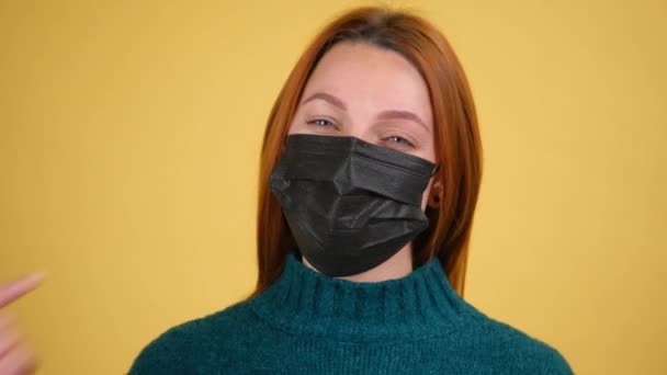 Giovane donna che indossa moderna maschera medica viso igienico nero per prevenire l'infezione respiratoria, influenza, coronavirus contagioso. — Video Stock
