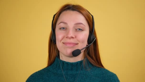 Ung kvinna i headset med mikrofon över gul bakgrund isolerad — Stockvideo