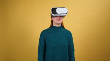 Şok olmuş genç bir kadın, VR kulaklıkla ağzını kapatarak 