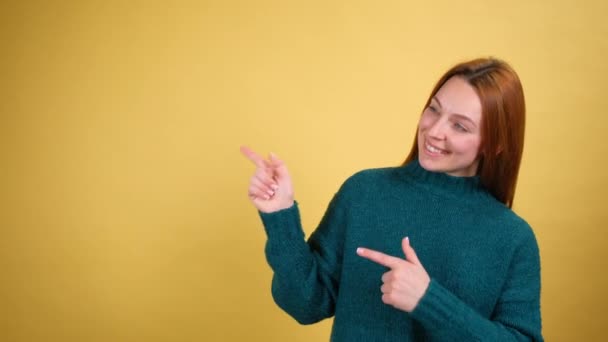 Wow, guarda che pubblicita 'assurda. Scioccato sorpreso giovane donna aprire la bocca con stupore e indicando spazio copia, mostrando parete vuota per il testo promozionale. interno isolato su fondo giallo — Video Stock