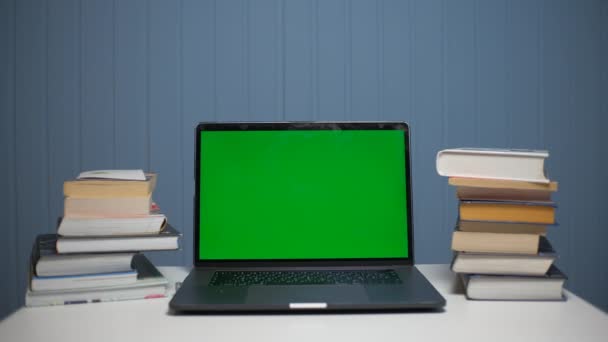 Groene scherm laptop computer zittend op een huiswerk bureau met boeken. — Stockvideo