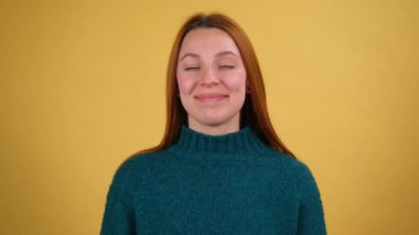 Stüdyoda sarı arka planda yalnız poz veren güzel, güzel genç bir kadın. İnsanlar samimi duygular, yaşam tarzı konsepti. Kameraya bak