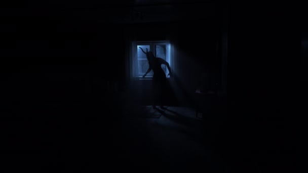 Satan with horns is standing at home in the dark by the window. A demon with horns — Stock Video