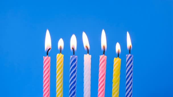 Kollektion von Geburtstagskerzen auf blauem Hintergrund, Konzept der Jubiläumsfeier, Licht ausblasen, Wünsche äußern — Stockvideo