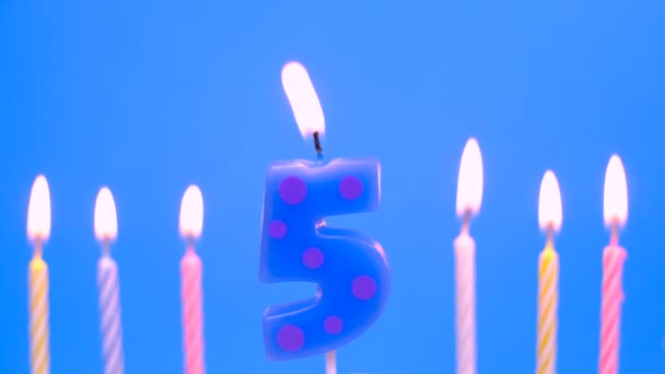 Accendi la candela numero 5 per il compleanno su sfondo blu — Video Stock