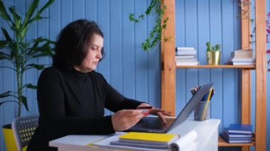 Elderly woman buys online using a credit or debit card. Online shopping, e-commerce, internet banking, spending money concept