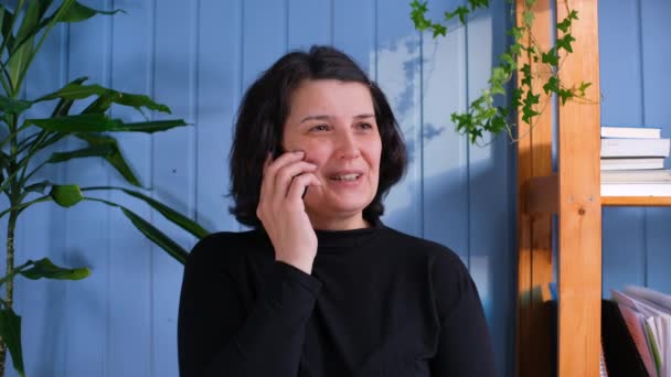 Mujer de mediana edad feliz hablando en el teléfono inteligente con amigos. — Vídeos de Stock