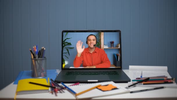 Молодой человек в наушниках с микрофоном проводит онлайн встречу разговор — стоковое видео