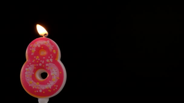 Number 8 birthday celebration candle against a black background. Copy space for text — Stock Video