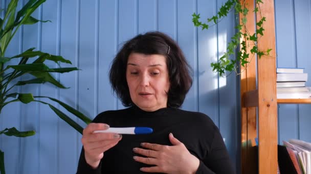 Happy παλιά γυναίκα παίρνει ένα τεστ εγκυμοσύνης και μόλις διαβάζει ότι είναι έγκυος, εκρήγνυται σε μια στιγμή ευτυχίας. Έννοια του: ivf, γέννηση, ζωή, οικογένεια. — Αρχείο Βίντεο
