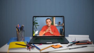 Bilgisayar aracılığıyla çevrimiçi video iletişimi. Genç adam internette öğretmenlik yapıyor.