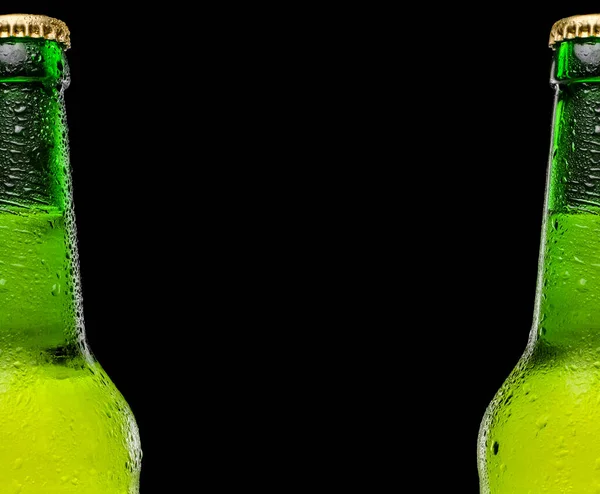 Két sörösüveg egymás után, fekete háttérrel. Helyet a szövegnek és a logónak. Cseppek az üvegre. Hideg és frissítő sör — Stock Fotó