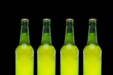 Siyah arka planda sıra sıra bira şişeleri