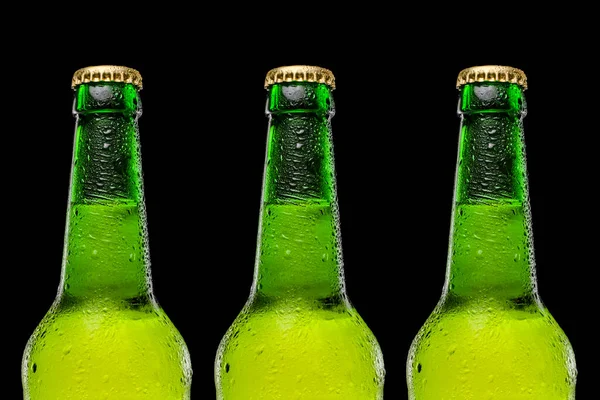Tre bottiglie di birra di fila su sfondo nero. Gocce sulla bottiglia. Birra fredda e rinfrescante — Foto Stock