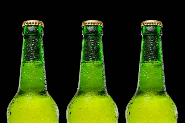 Arka planda arka arkaya üç bira şişesi. Şişenin üstüne damlatıyor. Soğuk ve ferahlatıcı bira.