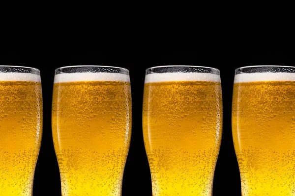 Una fila di bicchieri di birra con birra su sfondo nero. — Foto Stock